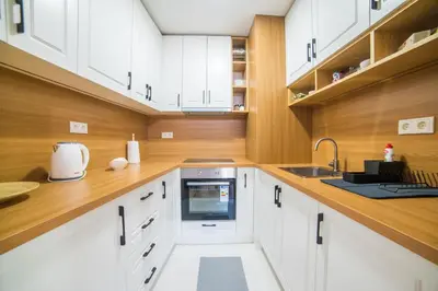 a kitchen with white cabinets and a sink at Liberty Apartments in Tuzla