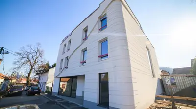 a white building on the side of a street at Liberty Apartments in Tuzla