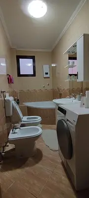 a bathroom with two toilets and a sink and a tub at Apartment Hatinac in Bihać