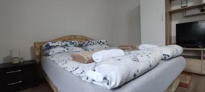 a bed with pillows and a television in a room at Apartment Hatinac in Bihać