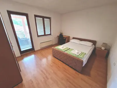 a bedroom with a bed and two large windows at Apartman Komfor in Banja Luka