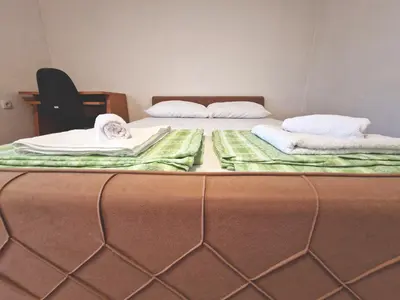 two beds in a room with towels on them at Apartman Komfor in Banja Luka