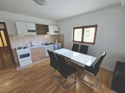 a kitchen with a table and chairs in a room at Apartman Komfor in Banja Luka