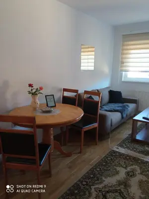 a living room with a table and a couch at Mercy Deluxapartment in Visoko
