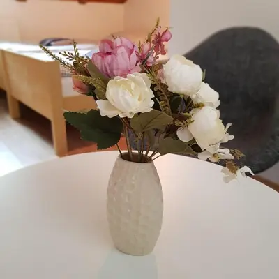 a vase filled with flowers sitting on a table at Studio apartman Ivana in Jajce