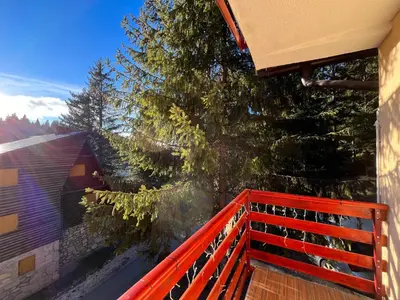 a balcony with a red fence and a tree at Villa 