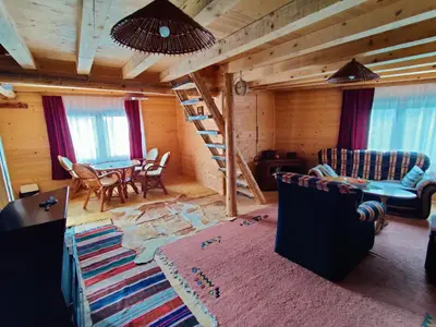 a living room with a staircase in a log cabin at Prokosko Resort in Fojnica