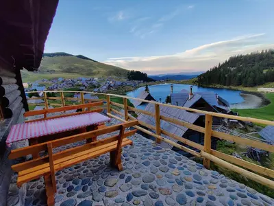 a bench sitting on a balcony overlooking a river at Prokosko Resort in Fojnica