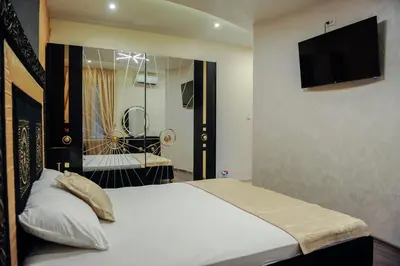 a bedroom with a bed with a television on the wall at Apartmani President I in Banja Luka