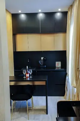 a black kitchen with a black table and chairs at Apartmani President I in Banja Luka