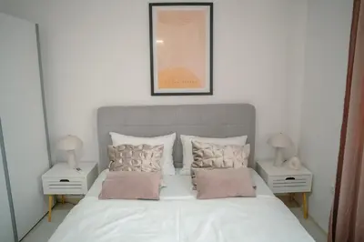 a bedroom with a white bed with two night stands at Paradise in Bihać