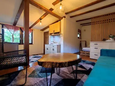 a living room with a table and a kitchen at RELAX HOME Visoko in Visoko