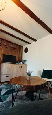 a living room with a wooden table and a kitchen at RELAX HOME Visoko in Visoko