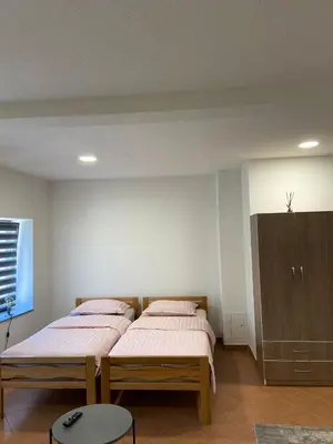 a bedroom with two twin beds and a cabinet at Apartman City in Livno
