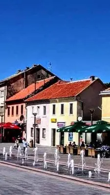 a street with a white fence in front of a building at Apartman City in Livno