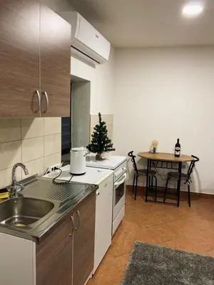 a kitchen with a sink and a table with a christmas tree at Apartman City in Livno