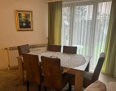 a dining room with a table and chairs and a window at Apartment Sky in Visoko