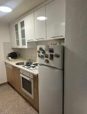 a kitchen with white cabinets and a white refrigerator at Apartment Sky in Visoko