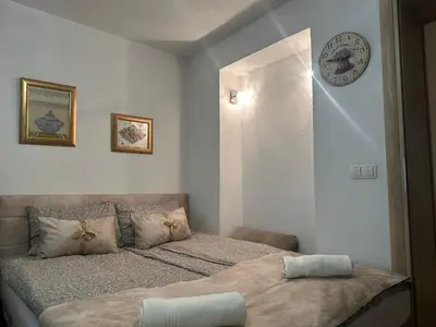 a bedroom with two beds and a clock on the wall at Apartment Sky in Visoko
