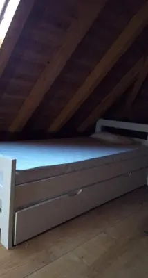 a bed in a attic with a wooden ceiling at Natural Paradise in Bosanska Krupa