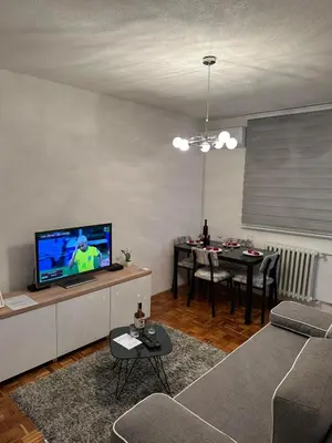 a living room with a couch and a tv and a table at Apartman Tamara in Doboj