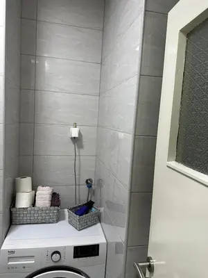 a bathroom with a washing machine in a room at Apartman Tamara in Doboj