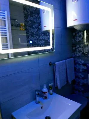a bathroom with a sink with a light above it at Apartman Tamara in Doboj