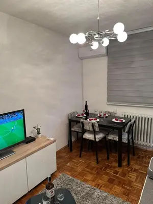 a living room with a dining table and a television at Apartman Tamara in Doboj