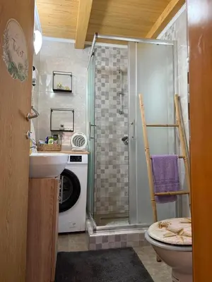 a bathroom with a shower and a washing machine at Otoka Josikovic in Šipovo