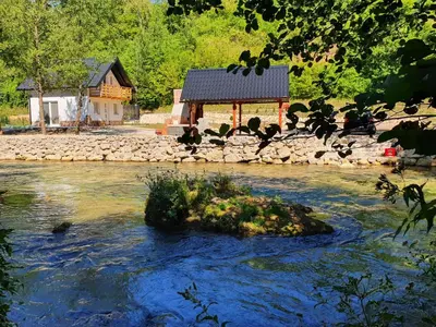 a building on the side of a river with a house at Otoka Josikovic in Šipovo