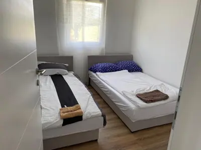 two beds in a small room with a window at Vikendica Fenix in Banja Luka