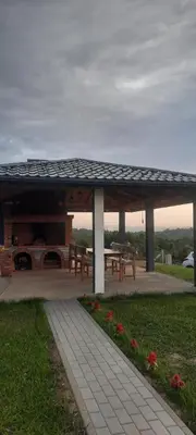 a pavilion with a picnic table and a grill at Vikendica Fenix in Banja Luka