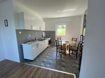 a kitchen and dining room with a table and chairs at Vikendica Fenix in Banja Luka