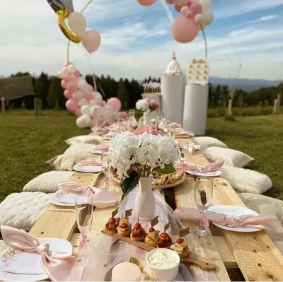 a picnic table with plates and flowers and balloons at Vikendica Fenix in Banja Luka