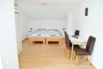 a room with a table and chairs and a bed at Apartman SUNCE in Jajce