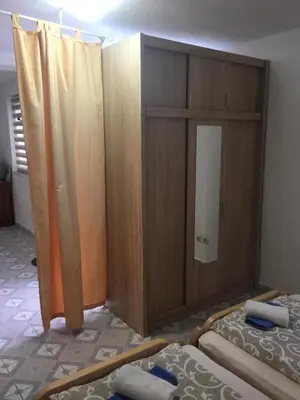 a bedroom with two beds and a wooden cabinet at Apartman SUNCE in Jajce