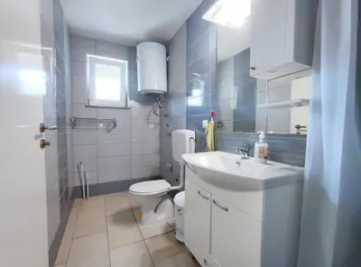 a bathroom with a white sink and a toilet at Apartman SUNCE in Jajce