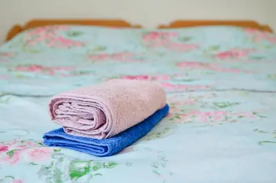 a pile of towels sitting on a bed at Apartman SUNCE in Jajce