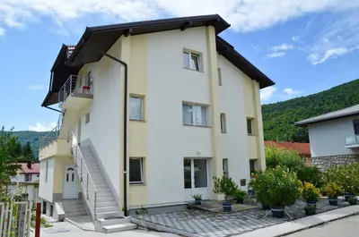 a large white building with stairs on it at Apartman SUNCE in Jajce