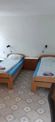 two twin beds in a room with two lamps at Apartman SUNCE in Jajce