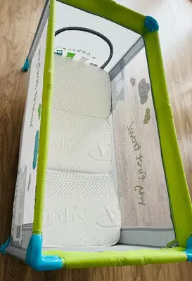 a green and white baby swing set with a book at Apartman Ana in Doboj