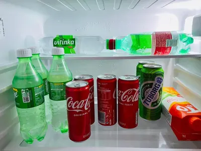 an open refrigerator filled with cocacola drinks and soda at Apartman Ana in Doboj