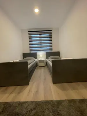 a room with two beds and a window at Ammirevole Ravne Apartments in Visoko