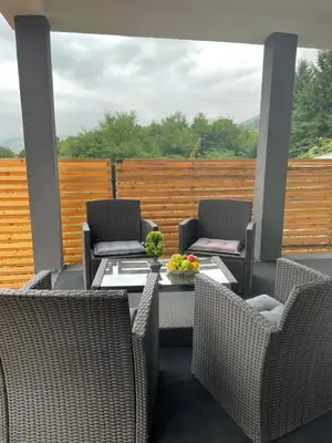 a patio with chairs and a table with a bowl of fruit at Ammirevole Ravne Apartments in Visoko