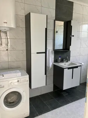 a bathroom with a washing machine and a sink at Slijepcevic in Teslić