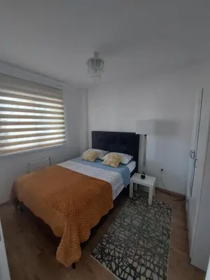a bedroom with a bed and a rug and a window at Apartman Vrbas sa Podzemnom garazom in Banja Luka