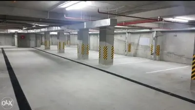 an empty parking lot with columns in a parking garage at Apartman Vrbas sa Podzemnom garazom in Banja Luka
