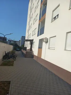a walkway next to a white building with a staircase at Apartman Vrbas sa Podzemnom garazom in Banja Luka