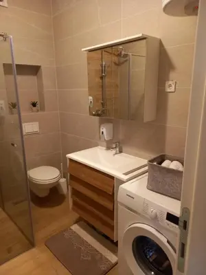 a bathroom with a washing machine and a washer at Apartman Vrbas sa Podzemnom garazom in Banja Luka