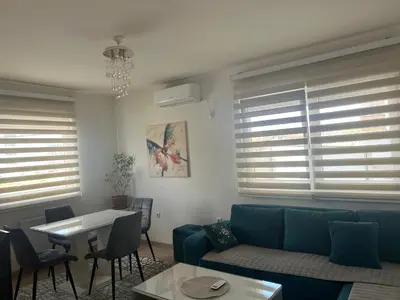 a living room with a blue couch and a table at Apartman Vrbas sa Podzemnom garazom in Banja Luka